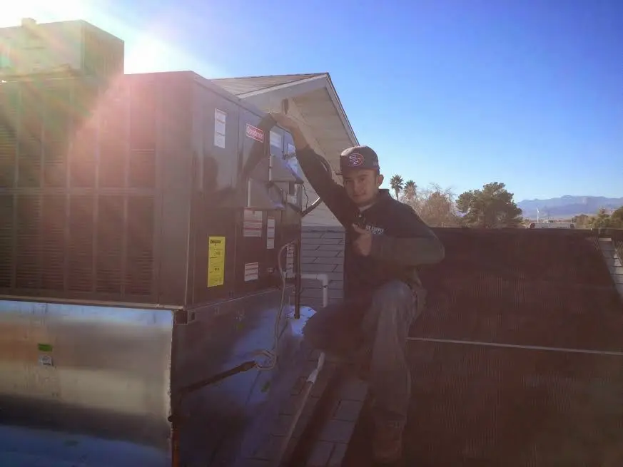 HVAC technician performing HVAC Inspection on a rooftop unit in Leesburg